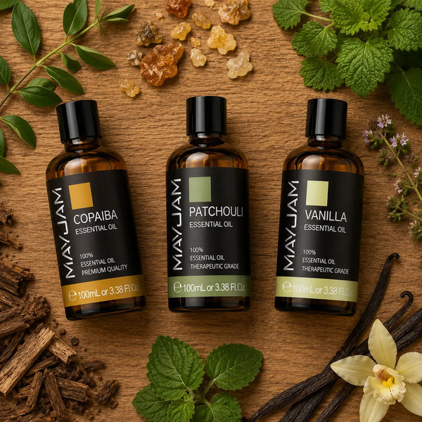 Három 100 ml-es illóolaj (copaiba, pacsuli és vanília) rusztikus fa asztalon felülnézetből, természetes növényi elemekkel, vaníliarudakkal, gyantával és faágakkal körülvéve.