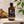 Load image into Gallery viewer, 100 ml-es szantálfa illóolaj borostyánszínű üvegben fekete kupakkal és külön üveg pipettával

